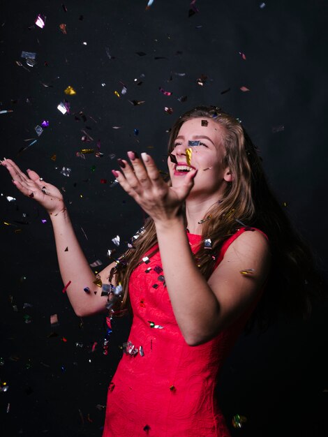 Happy woman in pink standing under spangles