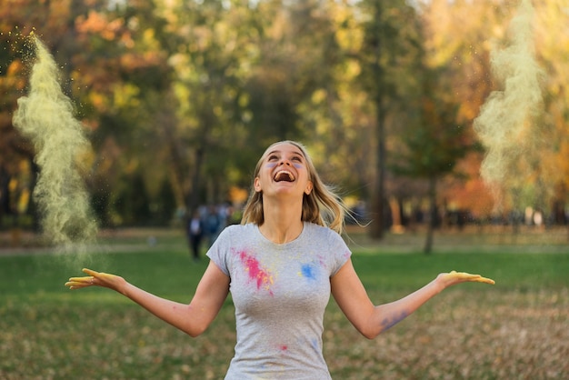 Бесплатное фото Счастливая женщина играет с пудрой цвета