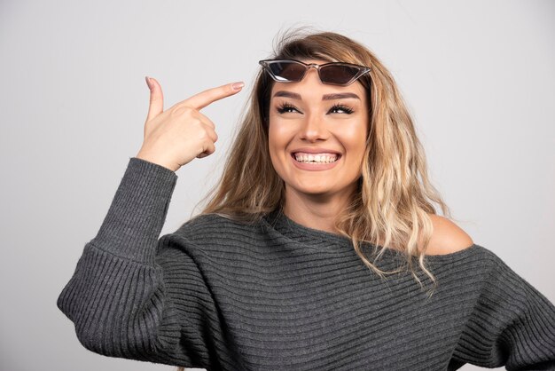 Happy woman pointing at her eyeglasses