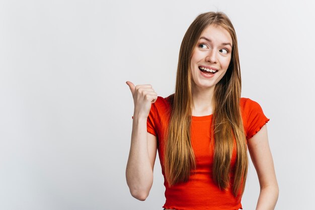 Happy woman pointing behind her 