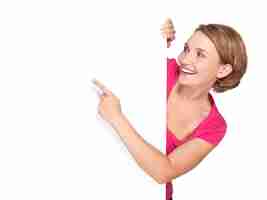 Free photo happy woman pointing with her finger on banner isolated on white wall