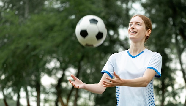 Счастливая женщина позирует с мячом