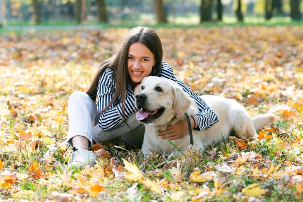 Счастливая женщина позирует с милой собакой