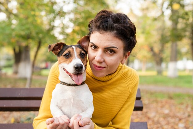 幸せな女が彼女の犬とポーズ