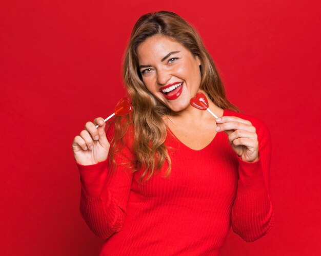 Happy woman posing with lollipops