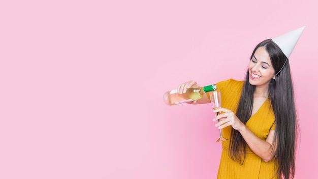 Счастливый женщина, наливание вина в стакан на розовом фоне