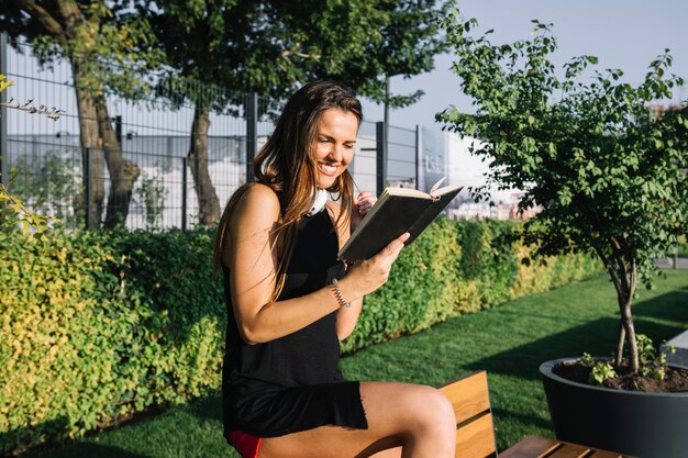 Happy woman reading book in park