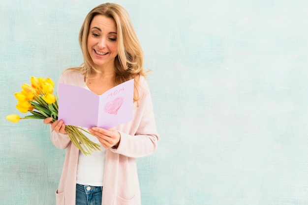 Free photo happy woman reading mother`s day postcard