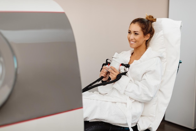 Free photo happy woman receiving oxygen therapy at hyperbaric chamber at health spa