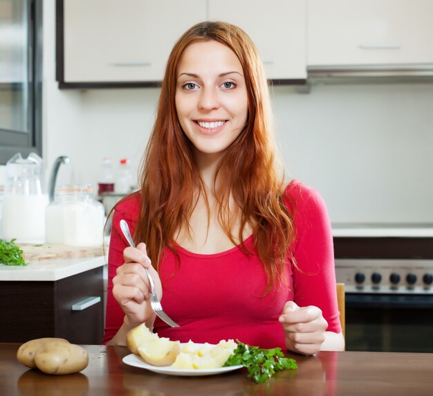 Happy woman in red eating jacket potatoes