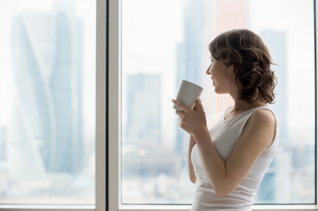 幸せな女性はホットドリンクでリラックス