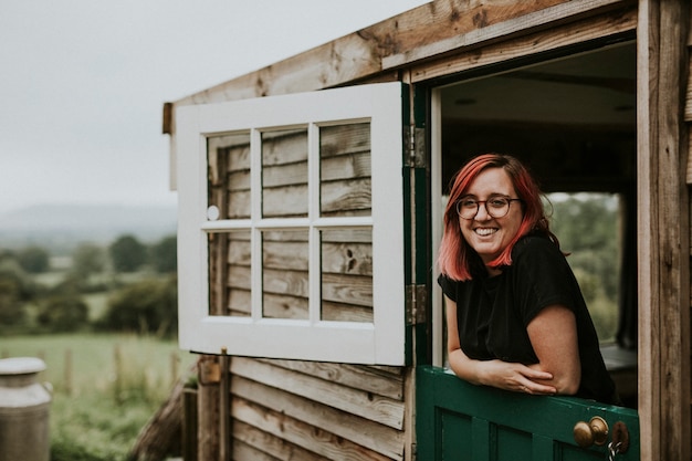 Donna felice in una casa di legno rurale