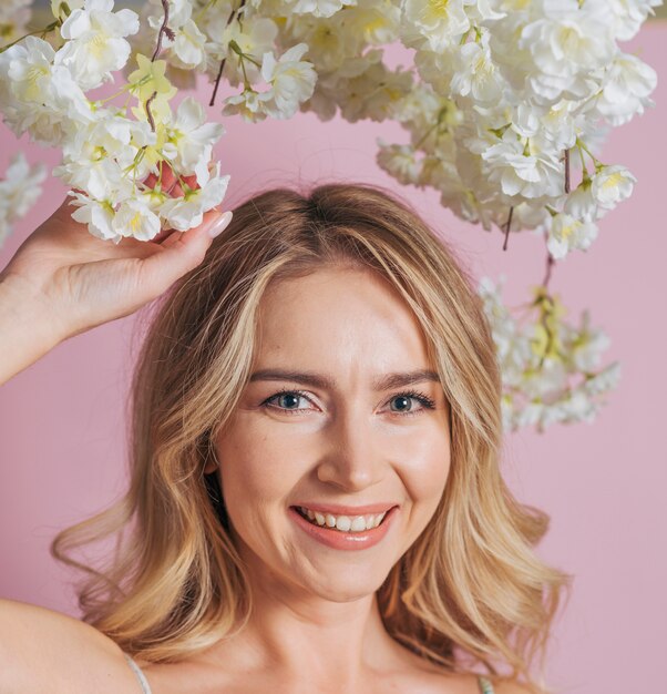 Happy woman's face holding bunch of white flowers