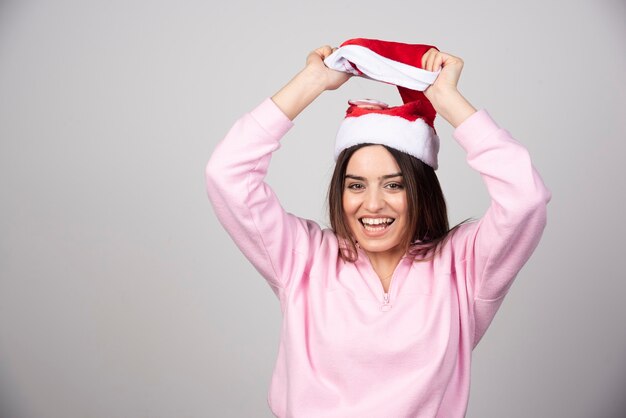 오버 헤드 모자를 들고 산타 클로스 빨간 모자에 행복 한 여자.