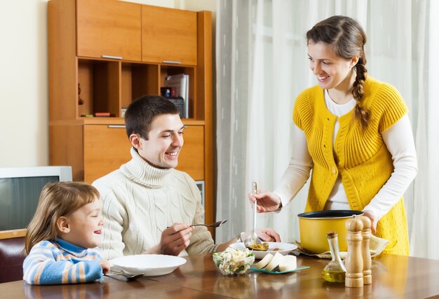 家族のためのスープを提供する幸せな女性