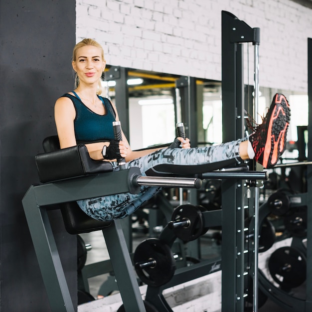 Happy woman on simulator in gym