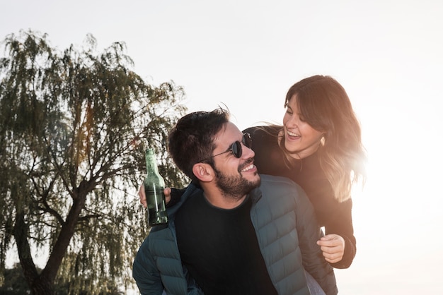 Happy woman sitting on back of man