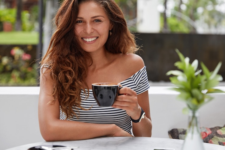 Free Photo happy woman sitting on a coffee shop