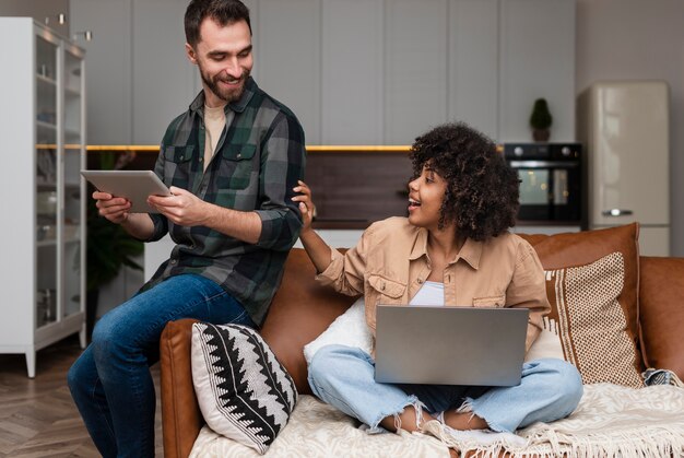 Happy woman sitting on sofa and looking at her boyfriend