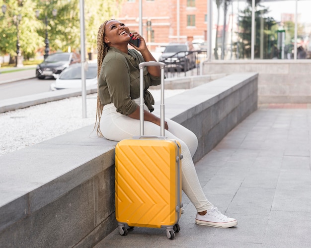 happy woman sitting and talking on the phone while traveling