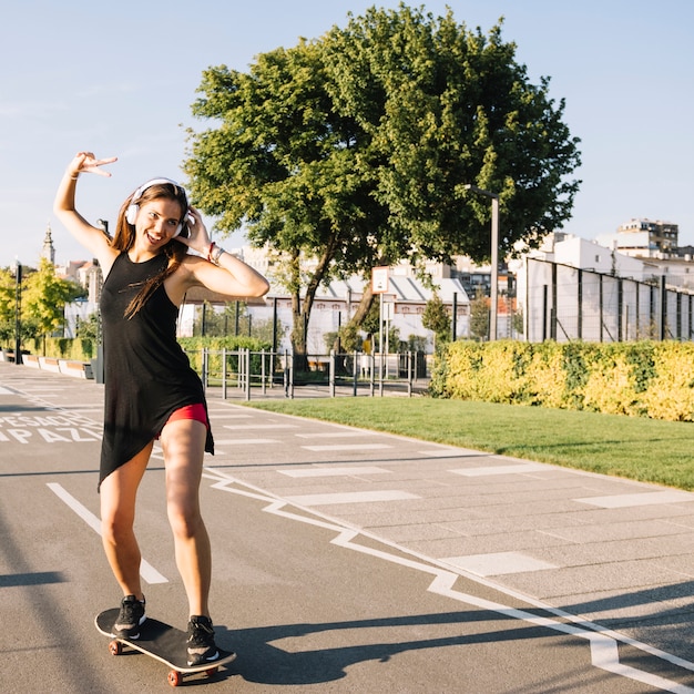 Happy woman skateboarding on street