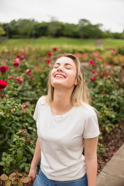 Happy woman standing in flower garden