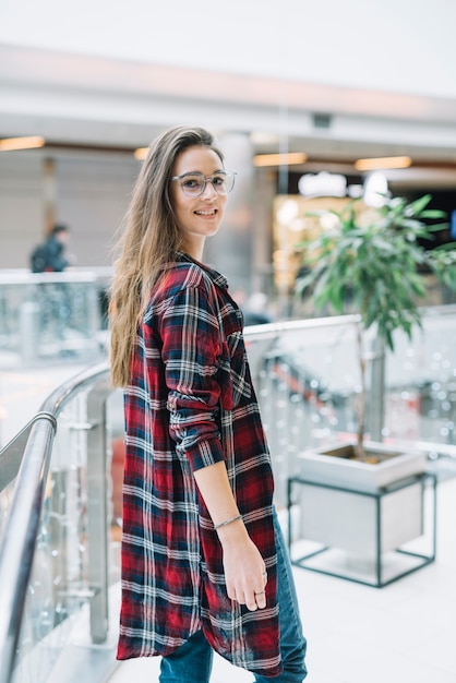 Donna felice che sta nel centro commerciale