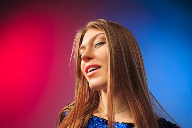 Happy woman standing, smiling on colored studio background. Beautiful female half-length portrait. Young satisfy woman.