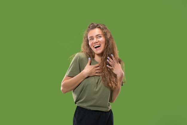 Happy woman standing and smiling isolated on green