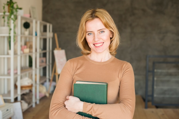 Foto gratuita donna felice in piedi con il libro