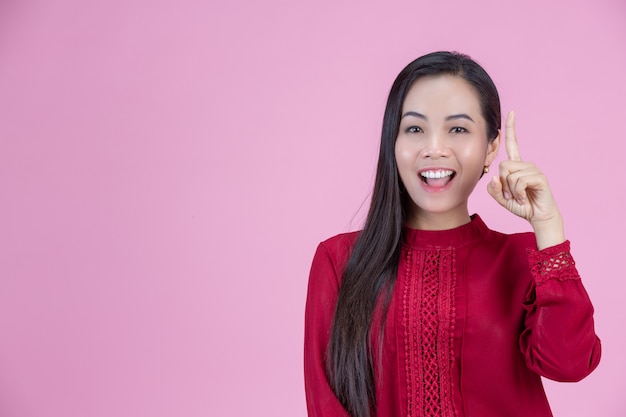 Happy woman standing with her finger pointing