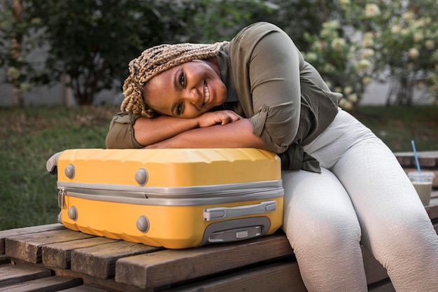 Free photo happy woman staying on her luggage with her head