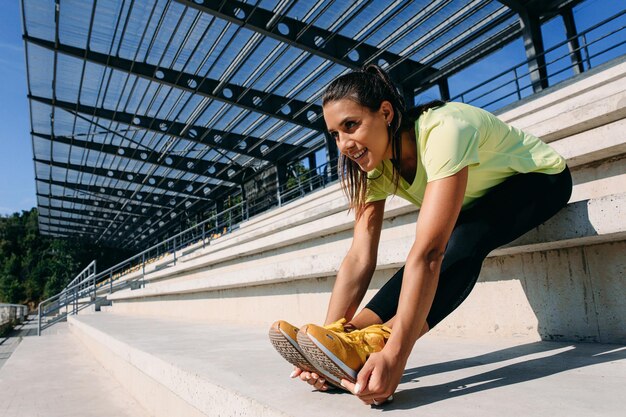 Happy woman stretching body while sitting on stairs