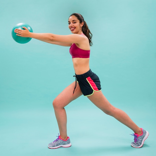 Happy woman stretching and training with a ball