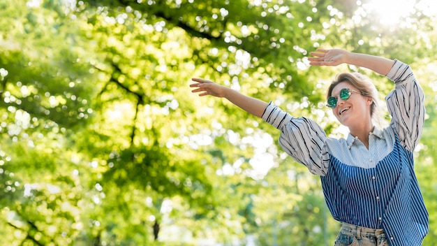 Free photo happy woman in summer park low view