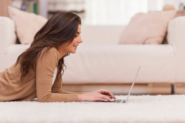 家でネットサーフィンをする幸せな女性