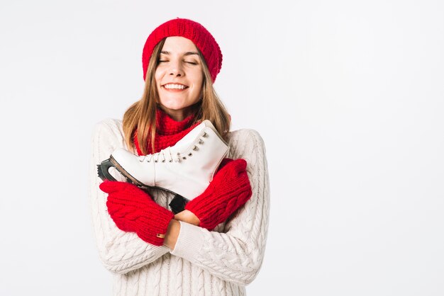 Happy woman in sweater holding skate