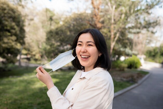 Happy woman taking mask off medium shot