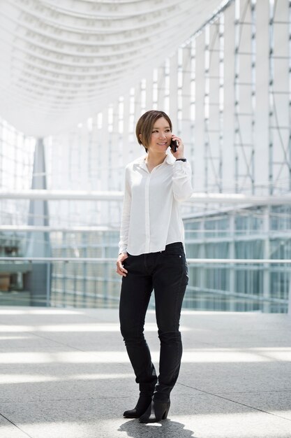 Happy woman talking on phone full shot