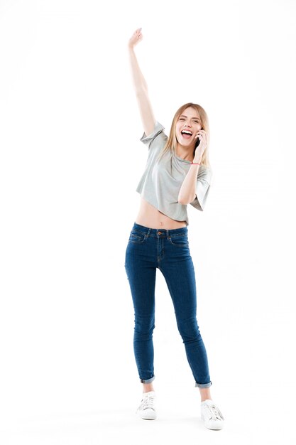 Happy woman talking on phone and raising hand