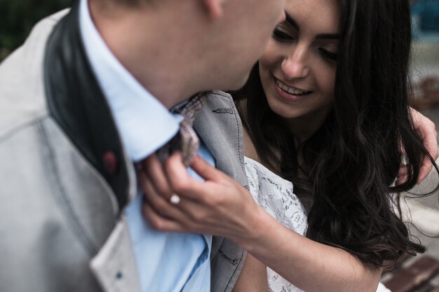 Happy woman touching her boyfriend's bow tie