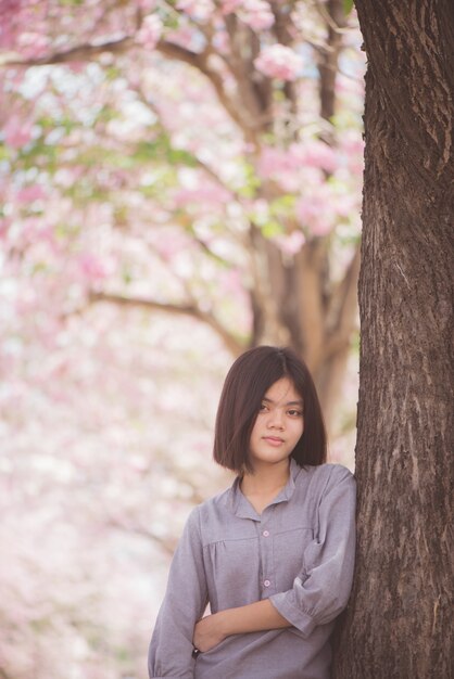 幸せな女性の旅行者は休暇で桜やサクラの花の木を自由に感じる