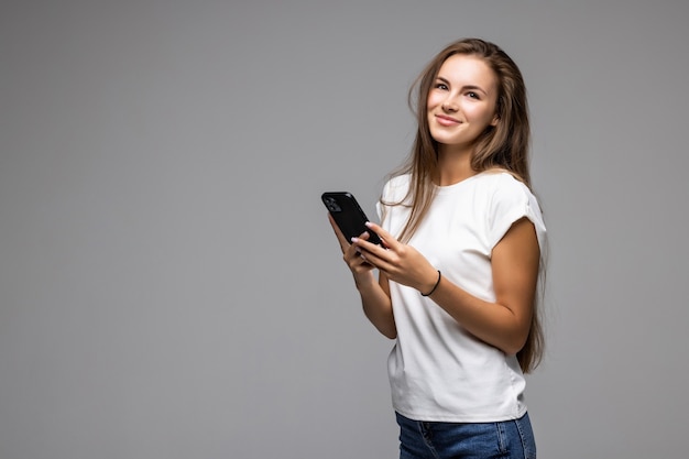 Free photo happy woman using smartphone on gray