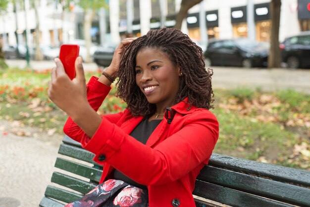 Счастливая женщина, используя смартфон в парке