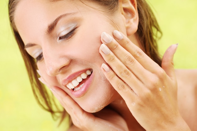 Happy woman washing her face