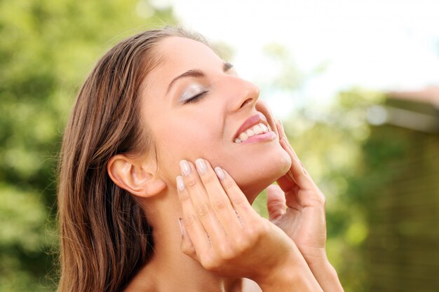 Happy woman washing her face