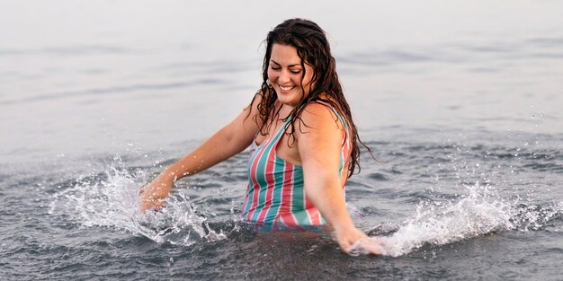 Счастливая женщина в воде на пляже