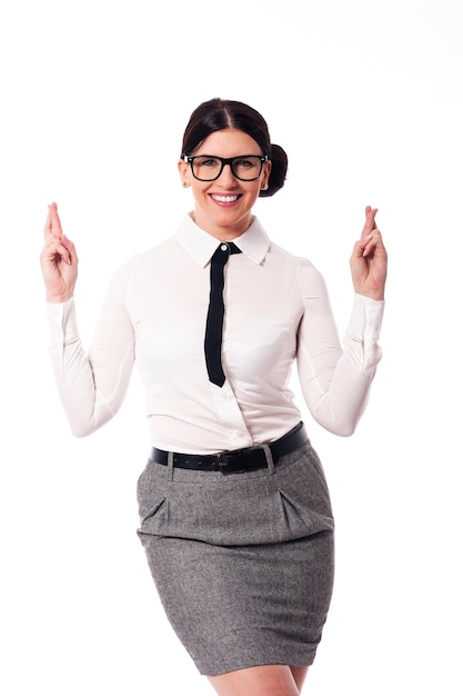 Happy woman wearing glasses with crossed fingers