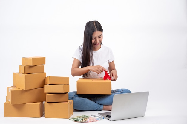 온라인 판매 온라인 작업 개념에 상자를 포장하는 행복한 여자