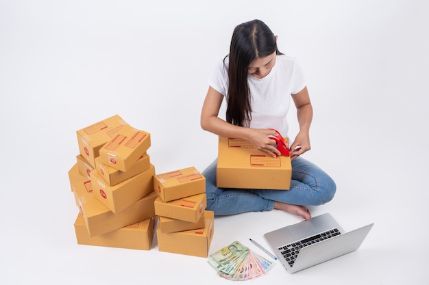 Счастливая женщина, которые упаковывают коробки в онлайн-продажах Концепция работы онлайн